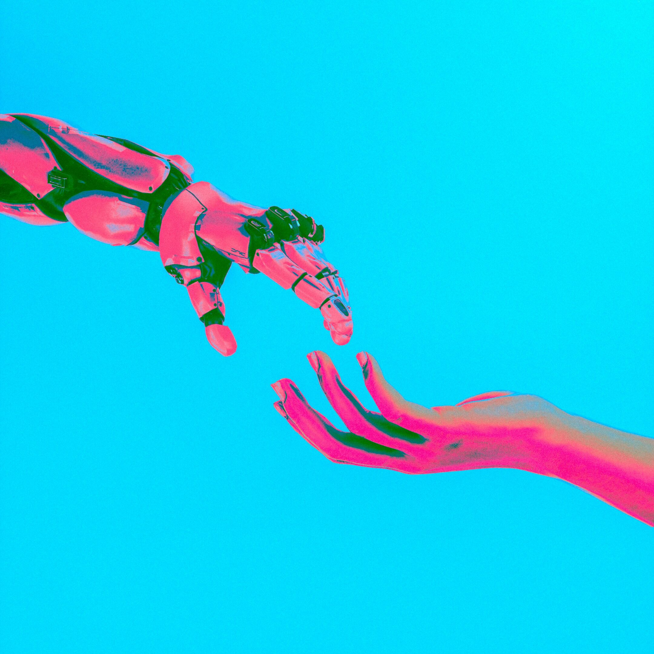 Robot hand reaching for human hand, photo by Cash Macanaya on Unsplash